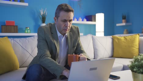 Man-using-laptop-alone-at-night-at-home.